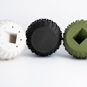 Puede incluir: Tres macetas redondas decorativas con un diseño geométrico único. Las macetas son blancas, negras y verdes.