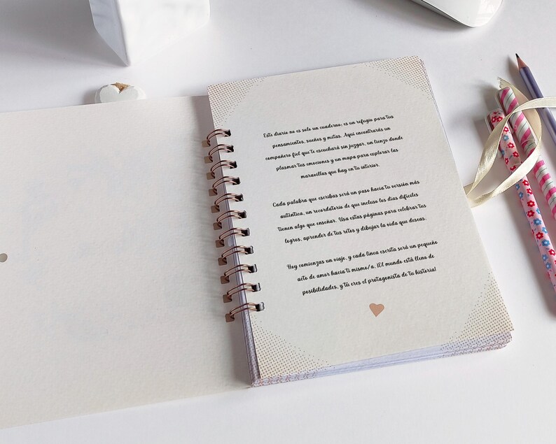 May include: A white spiral bound journal with a pink heart on the cover. The journal has a quote on the first page that reads: "This diary is not a condition, it is a refuge for your thoughts, anxieties, wishes and dreams.  A place where you can share your feelings and make your own journey.  A safe place where you can record and map your progress and discover the marvels that lie in you."