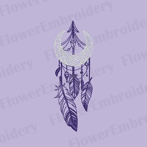 May include: A purple dreamcatcher design featuring a crescent moon, feathers, and beads. The design is embroidered with a detailed stitch pattern. The background is a light purple color. The text "Flower Embroidery" is visible.