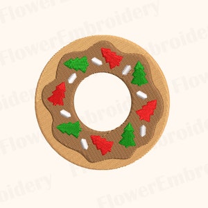 Op de afbeelding: Een bruine gingerbreadkoek in de vorm van een donut met rode en groene kerstboompjes en witte glazuur.