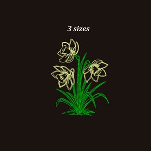 Pode incluir: Um desenho de bordado com três narcisos amarelos com folhas verdes. O desenho é etiquetado como "3 tamanhos".