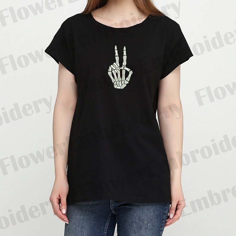 May include: Black t-shirt with a white skeleton hand making the peace sign.