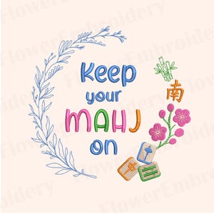May include: An embroidery design featuring the text Keep your MAHJ on in blue, pink, green, and orange. The design is framed by a blue stitched leafy branch on the left and a cluster of green bamboo, pink flowers, and three mahjong tiles on the right.