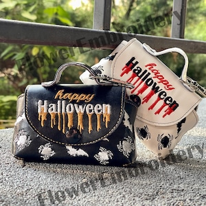 May include: Two small black and white purses with a Halloween theme. Both purses have a handle and a zipper closure. The black purse has a gold embroidered "happy Halloween" with dripping gold paint. The white purse has a red embroidered "happy Halloween" with dripping red paint. Both purses have a spider and bat design.