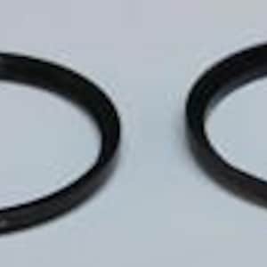 May include: Two black lens adapter rings are displayed on a white surface. Each ring is circular with a matte finish and has etched text along the outer edge. The rings are designed to adapt lenses to different camera bodies.