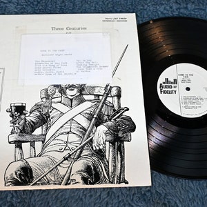 May include: Black and white vinyl record album cover featuring a drawing of a man in a military uniform sitting in a chair. The album title is "An Anthology of Band Music" and lists composers Bach, Handel, Lully, Haydn, and Mozart. The album is by the wind ensemble of the Leipzig Academy, directed by Capt. Erich Seifert.