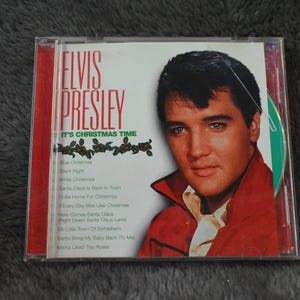 Może przedstawiać: Płyta CD "It's Christmas Time" Elvisa Presleya. Okładka albumu przedstawia Elvisa w czerwonej kurtce. Lista utworów zawiera "Blue Christmas" i "Silent Night". Płyta CD jest w przezroczystym plastikowym etui.