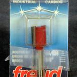 May include: A Freud industrial carbide router bit in its original packaging. The bit has a red head and a silver shaft. The packaging is clear plastic with a blue and white background and the Freud logo.