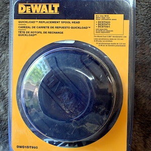 Puede incluir: Un cabezal de carrete de repuesto Quickload DeWalt en un embalaje de plástico transparente. El embalaje tiene una etiqueta amarilla y negra con el logotipo de DeWalt e información del producto. El cabezal es azul oscuro.