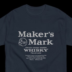 May include: A navy blue t-shirt with a white graphic of the Maker's Mark whiskey label. The label features the brand name, a star with the Roman numeral IV, and the text "Kentucky Straight Bourbon Whiskey Handmade". The label also includes the distillery's name, location, and bottle size.