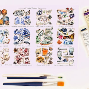 Puede incluir: Una colección de fragmentos de cerámica vintage, que incluyen un patrón de sauce azul y blanco, transferware verde y fragmentos de pipa de arcilla. La imagen también incluye dos tubos de pintura al óleo, uno azul y uno marrón.