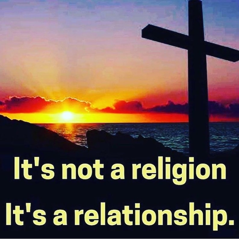 May include: A silhouette of a cross stands against a vibrant sunset over the ocean. The sky transitions from orange to purple, with the text "It's not a religion, It's a relationship." in white.