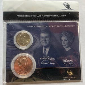 K&ouml;nnte beinhalten: Ein Set der United States Mint mit einer Presidential $1 M&uuml;nze und einer First Spouse Medaille. Das Set enth&auml;lt eine goldfarbene M&uuml;nze und eine kupferfarbene M&uuml;nze mit Portr&auml;ts von Ronald und Nancy Reagan. Die Verpackung tr&auml;gt den Text "PRESIDENTIAL $1 COIN AND FIRST SPOUSE MEDAL SET".