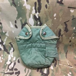 May include: Green canvas canteen cover with a zippered pocket and two metal snaps.