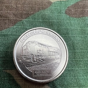 May include: Silver collectors series coin featuring a General Electric AC4400CW locomotive. The coin has a raised rim with the words "Collectors Series" around the edge.