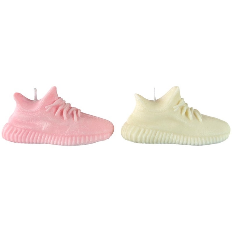May include: Two pairs of sneakers shaped candles, one pink and one white.