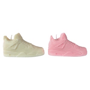 May include: Two pairs of sneakers, one white and one pink, in the style of a popular athletic shoe. The sneakers are made of a smooth, waxy material and have a classic design.