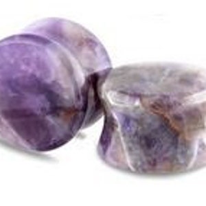 May include: Pair of amethyst stone ear gauges, one with a swirling pattern and the other with a more uniform color.