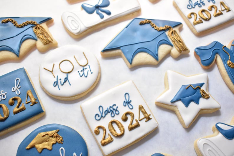 - White star shaped cookie with a royal blue graduation cap design with a gold tassel

- Royal blue graduation cap cookie with a gold tassel
