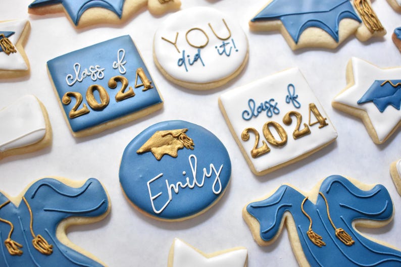 - Royal blue circle shaped cookie with "Emily" written on it in white and a gold graduation cap above it

- White circle shaped cookie with "YOU did it!" with "YOU" in gold and "did it!" in royal blue
