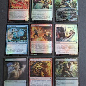 May include: Nine Magic: The Gathering trading cards are shown. The cards feature various creatures and spells, with vibrant artwork and text descriptions. The cards are from the collectible card game, with different mana costs and abilities.