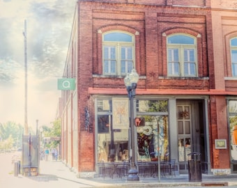 May include: A brick building with a storefront featuring a sign that reads "Morning Dew Farm Fresh Produce". The storefront has large windows and a door with a glass panel. There are tables and chairs set up outside the storefront.