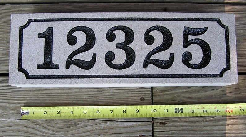 May include: A white rectangular stone house number plaque with black numbers "12325" in a decorative font.