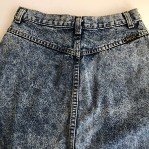 Puede incluir: Un par de jeans de mezclilla de lavado &aacute;cido de cintura alta con una etiqueta en el bolsillo trasero que dice "Guess".