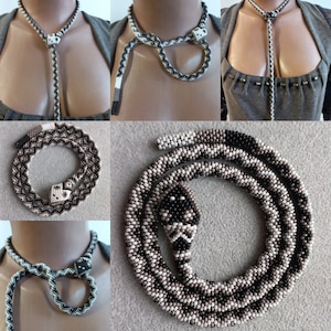 May include: A beaded snake necklace with a black, white and brown colour scheme. The snake is coiled and has a beaded head. The necklace is available in a variety of lengths.