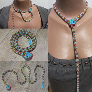 May include: A beaded snake necklace with a blue, red and yellow pattern. The necklace is long enough to be worn as a lariat or a choker.