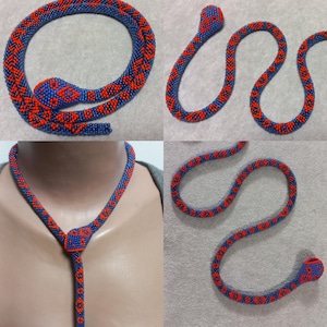 May include: A beaded snake necklace with a blue and red pattern. The necklace is made of small beads and is shaped like a snake. The snake has a head and a tail. The necklace is shown in three different positions.