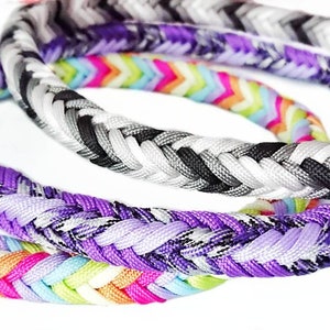 May include: Three braided rope collars featuring metal rings. One collar has a multi-colored chevron pattern in pink, orange, yellow, and blue. Another is purple and white. The third collar displays a black, grey, and white chevron design.