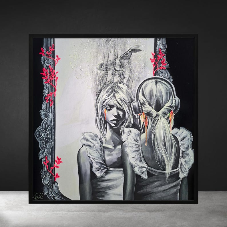 May include: Black framed artwork. A grayscale illustration depicts a person facing their reflection, wearing headphones. Red accents include tears and floral details. A paper airplane is above the person's head.
