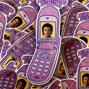 May include: A pink and purple cell phone sticker with the text "My Boyfriend Is Calling" and a picture of a man in the screen. The sticker is surrounded by other similar stickers with different colours and designs.