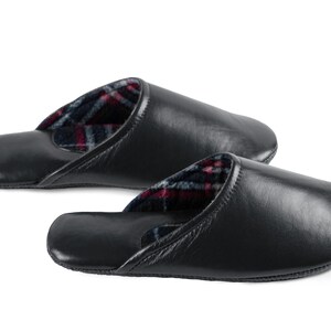 May include: A pair of black leather slippers with a plaid lining. The slippers are soft and comfortable, perfect for relaxing at home.