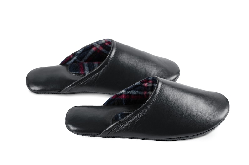 May include: A pair of black leather slippers with a plaid lining. The slippers are soft and comfortable, perfect for relaxing at home.