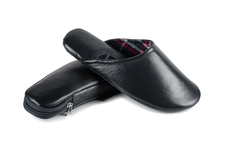 May include: A pair of dark blue leather slippers with a zippered pouch. The slippers have a plaid lining and are made of soft leather.