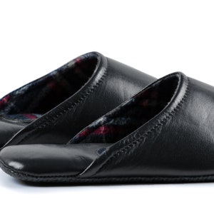 May include: Two pairs of black leather slippers with a plaid lining. The slippers have a closed toe and a slip-on design.