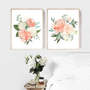 May include: Two framed prints of watercolor floral bouquets with peach and white flowers and green leaves on a white background.