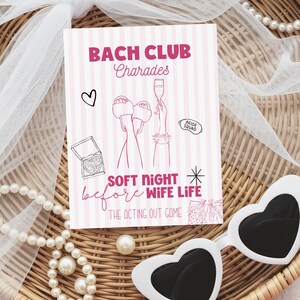 May include: A pink and white striped card with the text "BACH CLUB Charades" and illustrations of a heart, champagne, and slippers. The card also reads "SOFT NIGHT before WIFE LIFE" and "THE ACTING OUT GAME". A pair of white heart-shaped sunglasses and a pearl necklace are in the image.