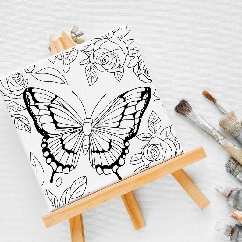 May include: A black and white line drawing of a butterfly and roses on a white canvas on an easel. The canvas is ready to be painted.