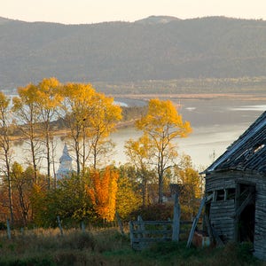 Old barn, last lights of falls on poplars, chuch and the lagoon of Barachois, Gaspe Coast
