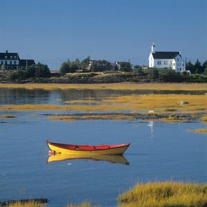 Yellow and red small boat in the fall at the bay of Pointe-aux-Orignaux, Rivière-Ouelle, St-Lawrence River