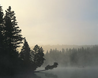 Fisherman in a canoe in a morning fog on Lac Caribou, Chaudière-Appalaches