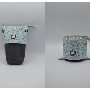 May include: A light blue zippered pouch with a black and white panda print. The pouch is open and folded down to show the black fabric lining.