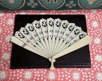 Abanico antiguo de celuloide marfilino de los años 20 para mujer con decoración calada de hadas aladas.
