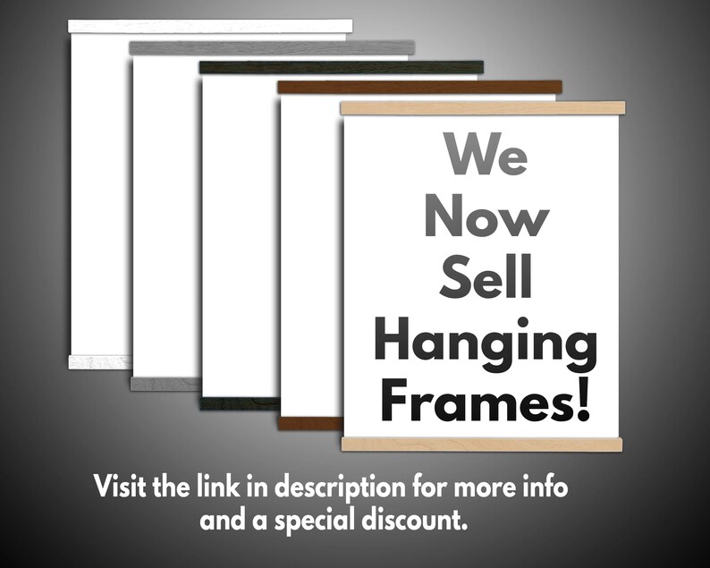 May include: A display of hanging frames with various wood finishes, including white, gray, dark green, brown, and natural wood. The frames hold white paper and the text "We Now Sell Hanging Frames!" is displayed on one of the frames.