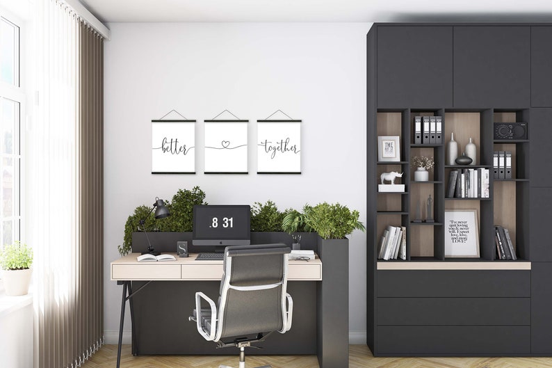 K&ouml;nnte beinhalten: Drei schwarze gerahmte Drucke mit wei&szlig;en Hintergr&uuml;nden, die an einer wei&szlig;en Wand h&auml;ngen. Die Drucke zeigen die W&ouml;rter "better", ein Herz und "together" in schwarzer Kursivschrift.