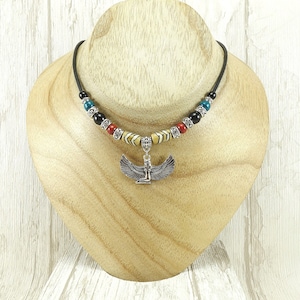 Collana girocollo in pelle con ciondolo raffigurante una dea alata egizia. Collana girocollo in stile etnico tribale egizio fatta a mano con ciondolo raffigurante una dea in argento.