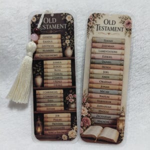 Könnte beinhalten: Zwei dekorative Lesezeichen mit dem Thema Altes Testament. Eines zeigt ein Bücherregal mit Buchtiteln, das andere listet Buchtitel auf. Beide haben florale Akzente und eine Quaste. Die Lesezeichen sind im Vintage-Stil gestaltet.